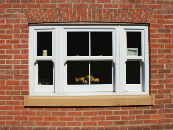 White painted timber sash window in a brick facade